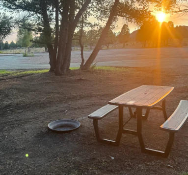 A picnic table and fire ring at a rv site at sunset at Soda Creek Campground in Soda Springs, Idaho.